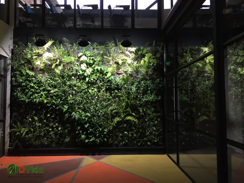 Patio interior del CFT Teodoro Wickel con muros verdes iluminados en dos pisos